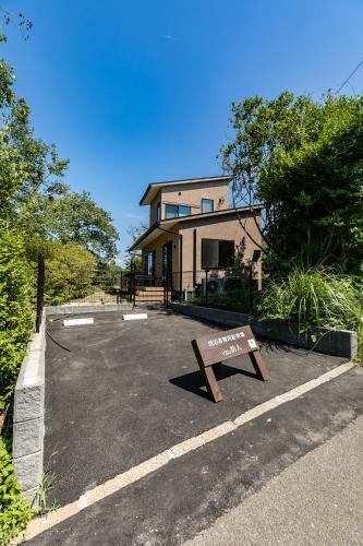 a parking lot with a sign in front of a house at Nokoshima Island Park Villa Sakimori in Fukuoka