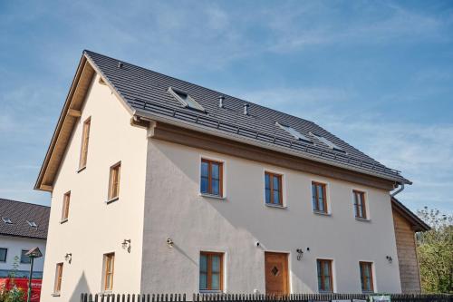 a large white house with a black roof at Haus Herzbluat in Peiting