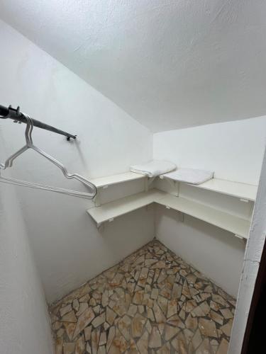 a walk in closet with white shelves and rocks at SunuSal One Bedroom Studio Apartment SS3-CHERNO in Sere Kunda