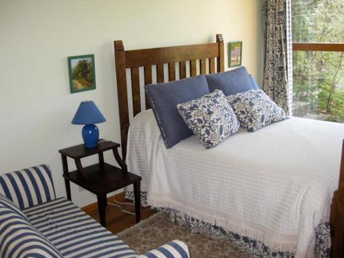 ヴィエイラ・ド・ミーニョにあるCasa Pala Luarのベッドルーム1室(青い枕と椅子付きのベッド1台付)
