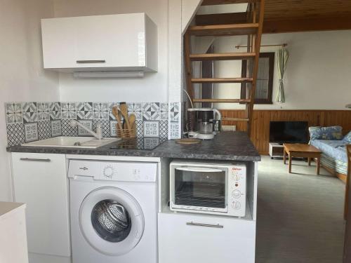 une cuisine avec un lave-linge et un micro-ondes dans l'établissement SP520-M344 Appartement 2 pièces SAINT PIERRE LA MER, à Saint Pierre La Mer