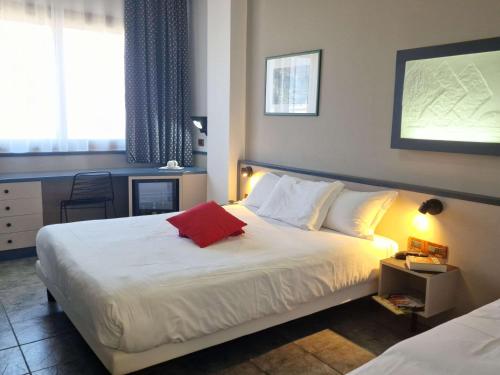 a bedroom with a bed with a red pillow on it at President Hotel Palermo in Palermo