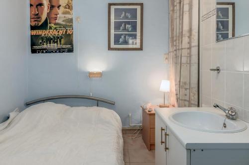 a bathroom with a bed and a sink and a tub at Europe 0402 in Sint-Idesbald
