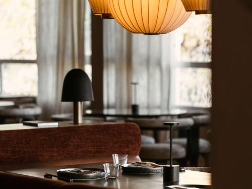 a dining room with two tables and a lamp at Mondrian Ibiza in Cala Llonga