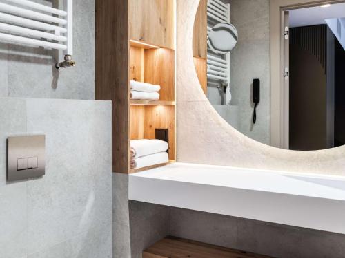 a bathroom with a white sink and a mirror at Mövenpick Resort & Spa Karpacz in Karpacz