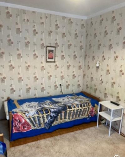 a bedroom with a bed and a small table at Квартира недалеко от погранпункта in Narva