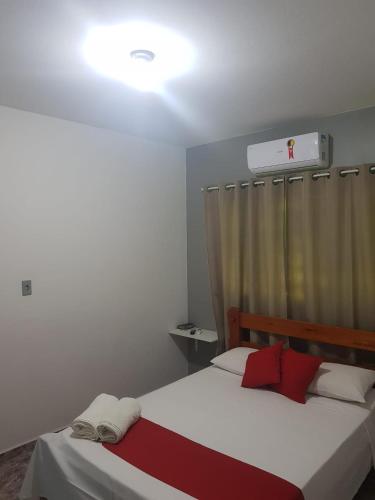 a bedroom with two beds and a window with a heater at Pouso Tião da Morena Suítes Êconomicas in Pirenópolis