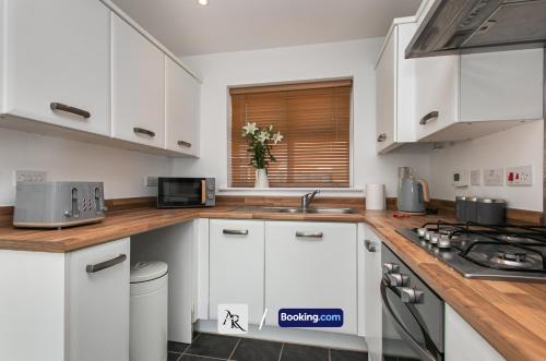 a kitchen with white cabinets and a counter top at Stylish House By AR Properties Short Lets & Serviced Accommodation Colchester in Colchester