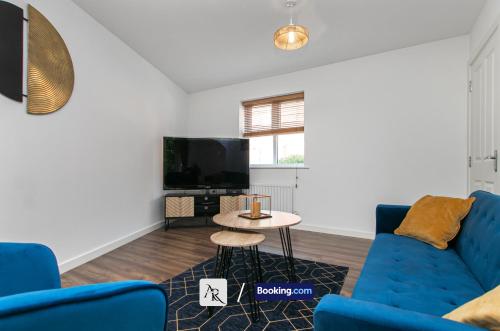 a living room with a blue couch and a table at Stylish House By AR Properties Short Lets & Serviced Accommodation Colchester in Colchester