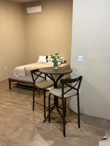 a table with chairs and a bed in a room at Los Kinotos Mini Casa Chuy in Chuí