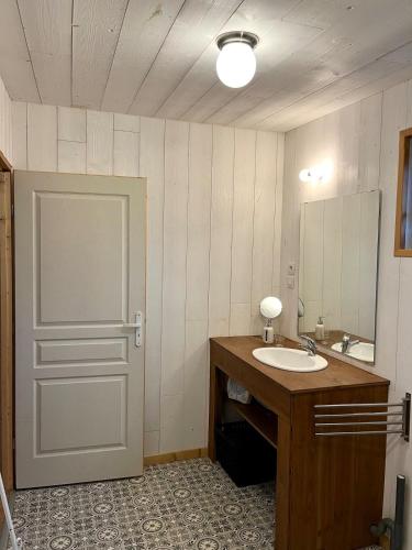 La salle de bains est pourvue d'un lavabo, d'une porte et d'un miroir. dans l'établissement Au Chalet Bourguignon 5, à Salives