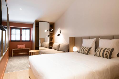 ボルドーにあるCENTRAL Hôtel Bordeaux Centreのベッドルーム(大きな白いベッド1台、ソファ付)