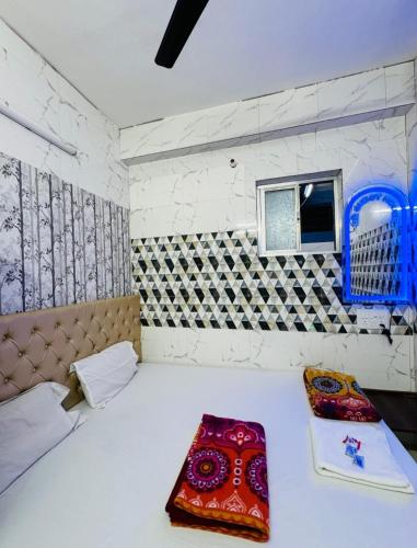a room with a bed and a couch and a window at RR Guest House in Kolkata