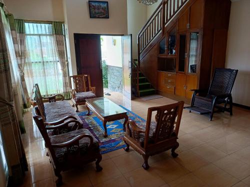 a living room with a glass table and chairs at Rumah Oma Lembang in Lembang