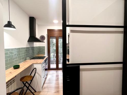 a kitchen with white cabinets and a counter top at Apartaments Casa Mata - L'Amfitriona in Esterri d'Àneu