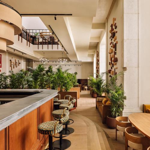 a restaurant with a bar with chairs and plants at Locke de Santa Joana in Lisbon