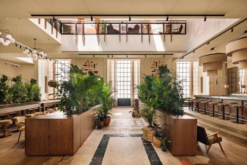 a large room with potted plants and tables at Locke de Santa Joana in Lisbon