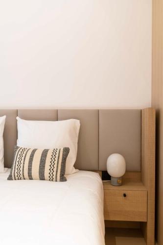 a bed with white sheets and a lamp on a night stand at CENTRAL Hôtel Bordeaux Centre in Bordeaux