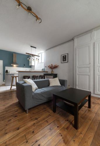 a living room with a couch and a table at Le Cocon - Appartement cœur de ville avec vue in Clermont-Ferrand