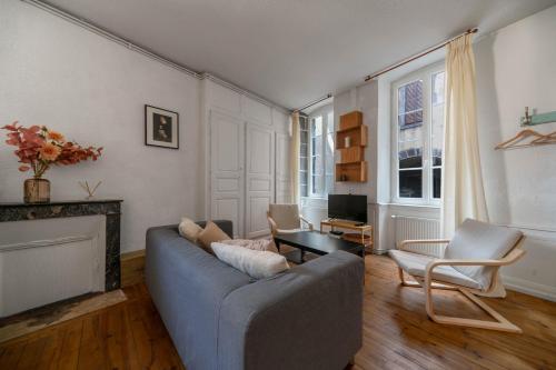 a living room with a couch and a fireplace at Le Cocon - Appartement cœur de ville avec vue in Clermont-Ferrand