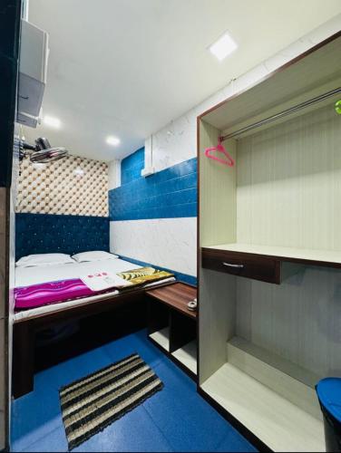 a small room with a bed and a closet at RR Guest House in Kolkata