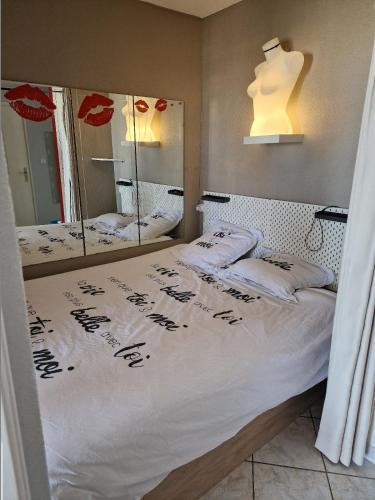 - une chambre avec un lit et deux miroirs dans l'établissement Naturiste Cap d'Agde Héliopolis F 61, au Cap d'Agde