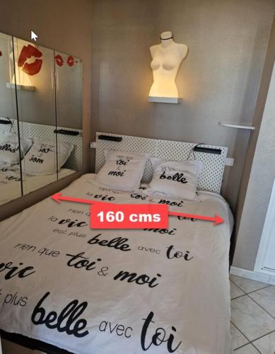 une chambre avec un lit avec un panneau dessus dans l'établissement Naturiste Cap d'Agde Héliopolis F 61, au Cap d'Agde