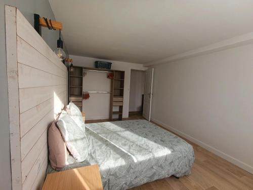 a small bedroom with a bed and a refrigerator at Maison de campagne in Sceaux-dʼanjou