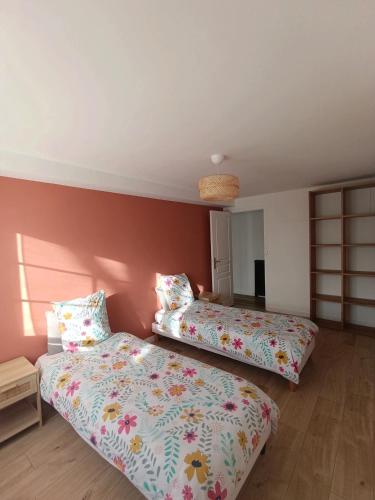 - 2 lits dans une chambre aux murs roses dans l'établissement Maison de campagne, à Sceaux-dʼanjou