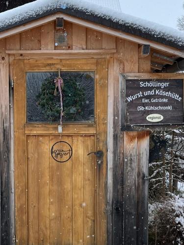 a wooden building with a door with a sign on it at Schittlerhaus in Oberstdorf