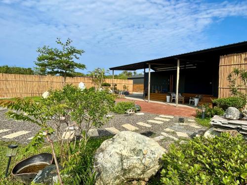 a garden with rocks and a building at 夏日禾風庭園包棟 in Checheng