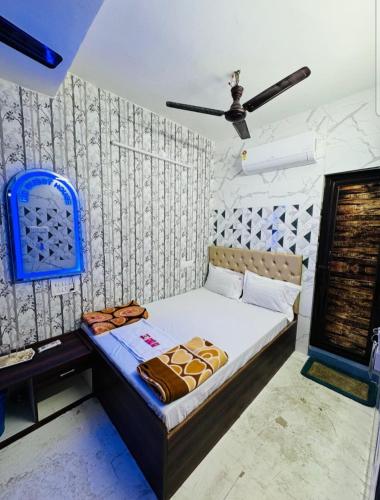 a bed in a room with a ceiling fan at RR Guest House in Kolkata