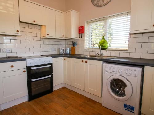 a kitchen with a washing machine and a dishwasher at Hillview in Kidderminster
