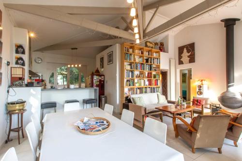 une salle à manger avec une table et des chaises blanches dans l'établissement Paradis pleine nature en bord de mer, à Saint-Georges-de-Didonne