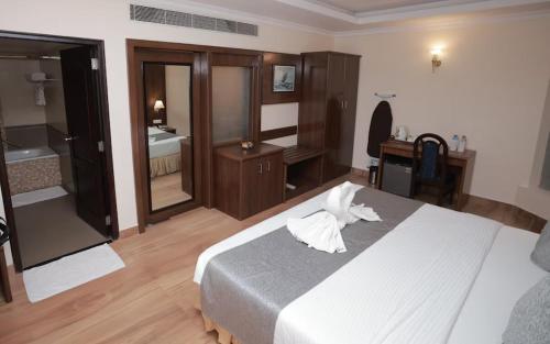 a hotel room with a bed and a bathroom at The Quilon Beach Hotel and Convention Center in Kollam