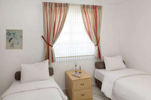 two beds in a room with a window at Nice Sea View Elegant Apartment in Athens