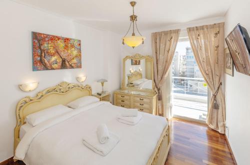 a bedroom with a white bed and a mirror at Nice Sea View Elegant Apartment in Athens