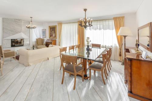 a dining room and living room with a glass table and chairs at Nice Sea View Elegant Apartment in Athens