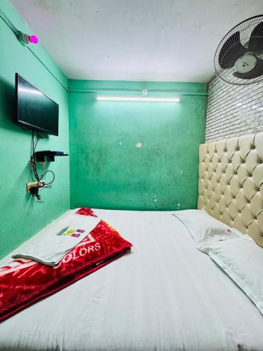 a bed in a room with a green wall at RR Guest House in Kolkata