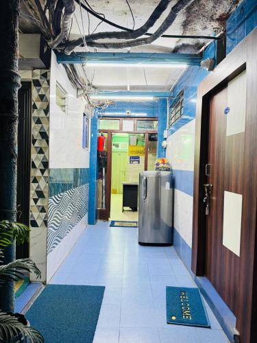 a hallway with a door in a room with blue walls at RR Guest House in Kolkata