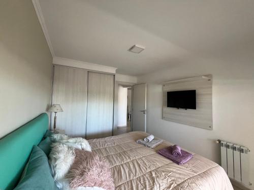 a bedroom with a bed and a flat screen tv at Domus piso 2 in Necochea