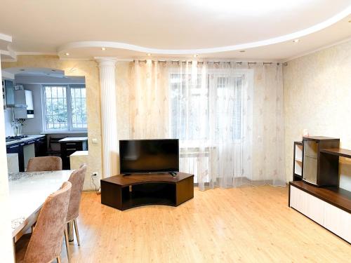 un salon avec une télévision et une table dans l'établissement Center 2 bedrooms Hajdeu, à Chişinău