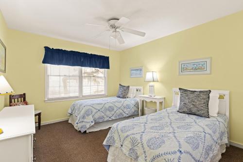 a bedroom with two beds and a ceiling fan at OceanWood, Unit 112 in East End
