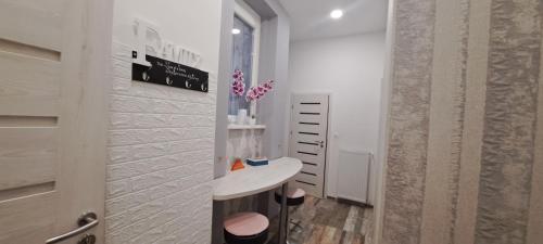 Biały pokój ze stołem i wazonem w obiekcie Pompár Belvárosi Apartman w Segedynie