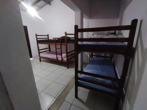 a room with two bunk beds in a room at Quarto compartilhado in Bertioga