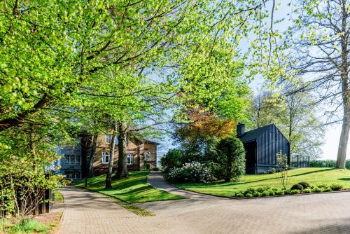 a driveway leading to a house with a barn at Aarskogs Boutique Hotel in Glücksburg
