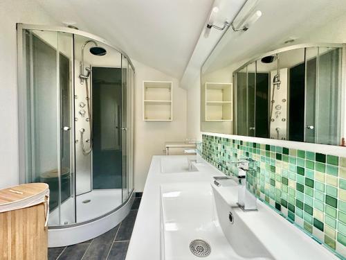 une salle de bain avec deux lavabos et une douche dans l'établissement Le Refuge du Palais, à Le Palais-sur-Vienne