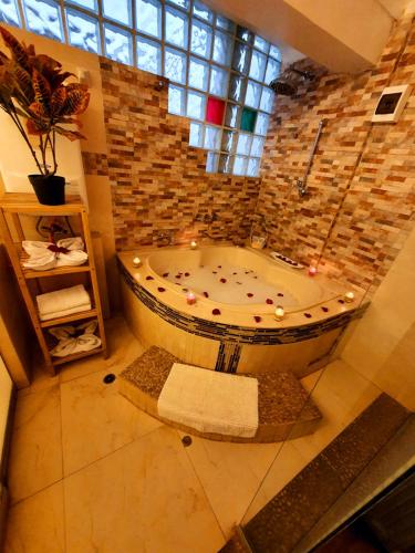 un bagno con una grande vasca in un muro di mattoni di Hotel Cusco Museo a Cuzco