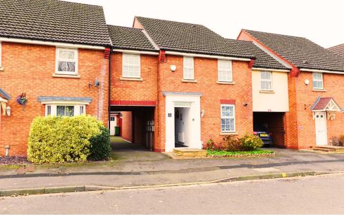 a row of red brick houses with a driveway at Roomy Spark Home with Parking, Garden, Wi-Fi in Wellington