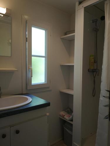 une salle de bain avec un lavabo et une fenêtre dans l'établissement Mobil-Home à louer dans le golfe de Saint-Tropez, à Gassin